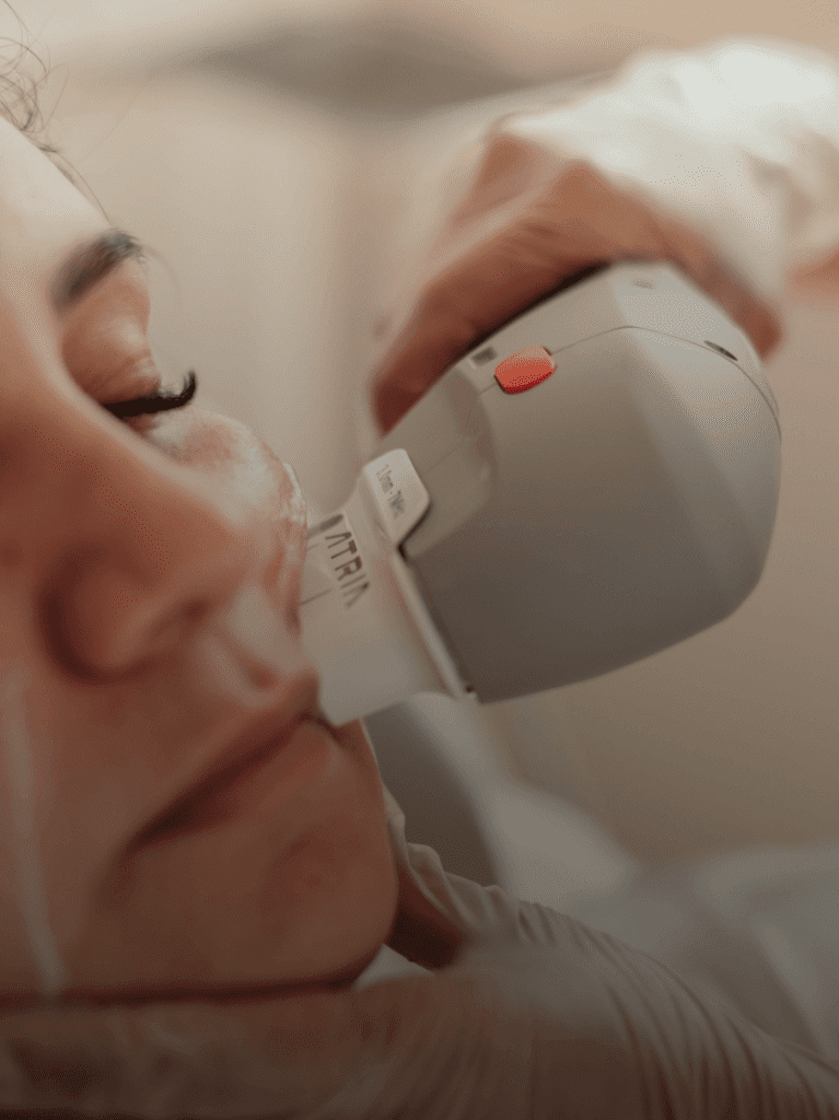 Paciente recebendo tratamento facial de ultrassom micro e macrofocada.